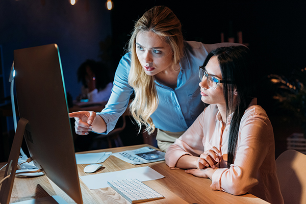 two young professionals examining computer screen